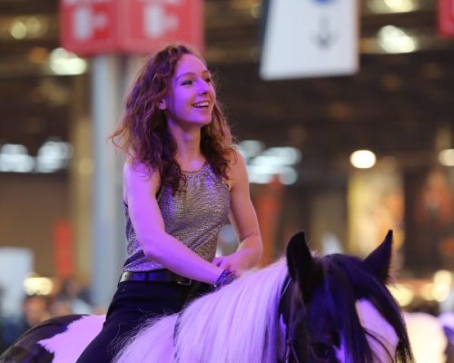 Photo de Coline Gosset sur un cheval noir et blanc