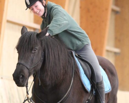 Photo de Coline Gosset sur un cheval noir